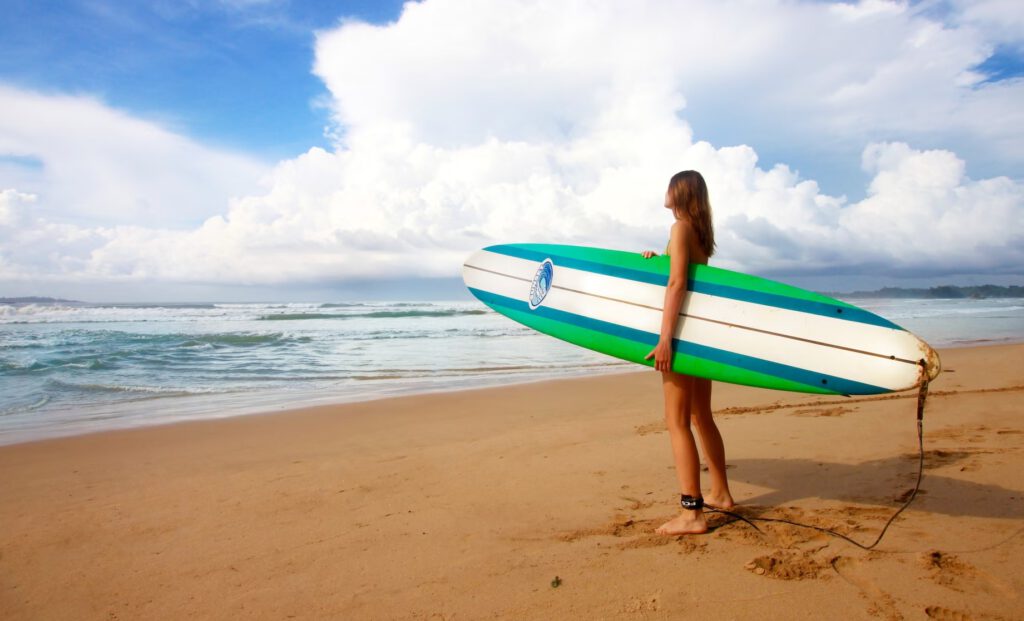 Weligama girl holding a surfboard on the beach